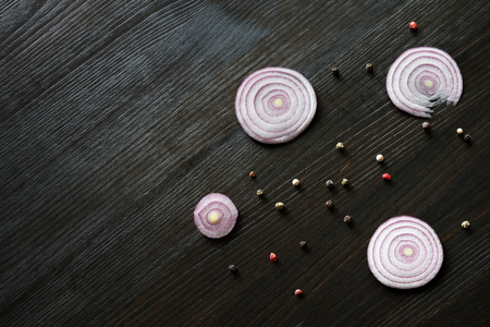 wood background with onion slices and bell pepperの写真素材