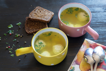 soup with meatballs in colorful bowl with slices of grain breadの写真素材