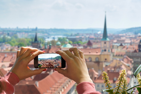 woman taking picture of Old Town in Prague with a smartphoneの写真素材