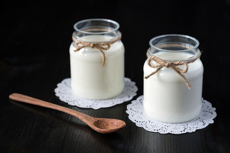 natural yogurt in a jar on the dark backgroundの写真素材