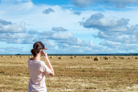 young woman using mobile phone outdoorsの写真素材