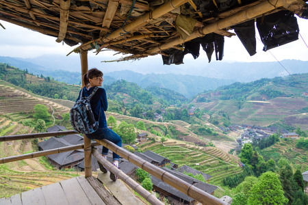traveling young woman with backpack on the background of rice terrace in Chinaの写真素材