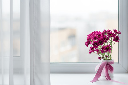 pink chrysanthemums bouquet in vase over window background