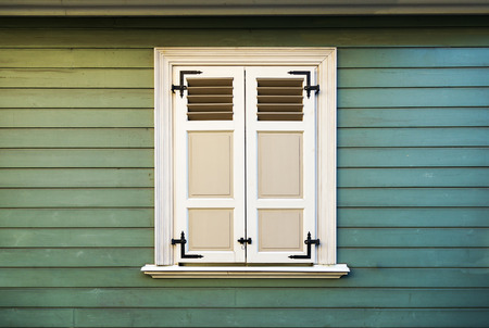 white window shutters and old green wood wall