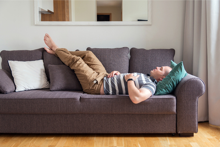 man sleeping on the couchの写真素材