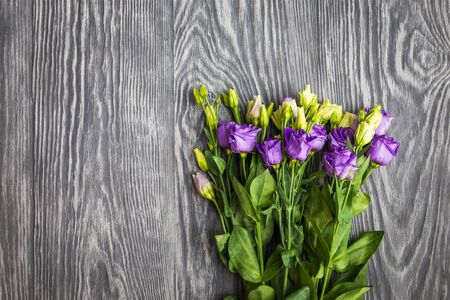 Beautiful bouquet from purple eustoma flowers on dark woodenの写真素材