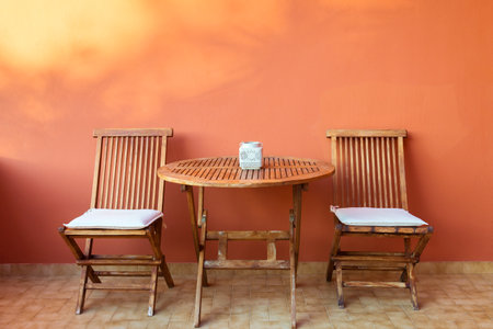 empty wooden table and chairs on the terrace on a summer dayの写真素材