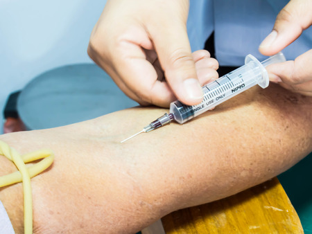 Nurse collecting a blood from a patientの写真素材