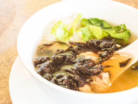 White Bowl of Vegetable Soup with Spoon closeup on Wooden backgroundの写真素材