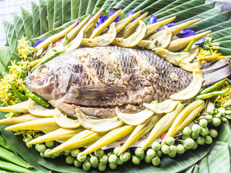 Close up a freshly steamed whole fish covered with herbsの写真素材
