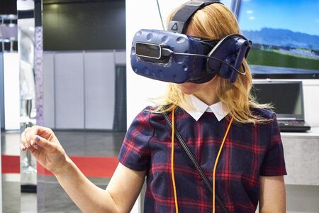 RUSSIA, MOSCOW - APRIL, 04, 2019 A girl looks into a virtual reality helmetのeditorial素材