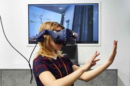 RUSSIA, MOSCOW - APRIL, 04, 2019 Young blonde girl in augmented reality headset.のeditorial素材