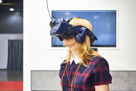 RUSSIA, MOSCOW - APRIL, 04, 2019 A girl looks into a virtual reality helmet