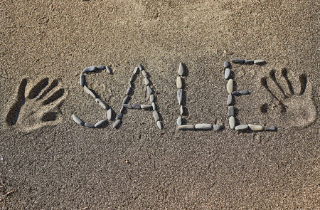 The word "sale" of stones on the sand.の写真素材