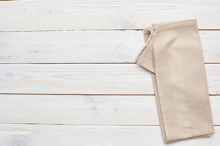 Kitchen beige towel on a white wooden background. Copy space. horizontal shotの写真素材