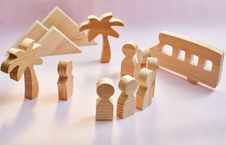 excursion concept. wooden figures of people, palm trees, mountains, bus