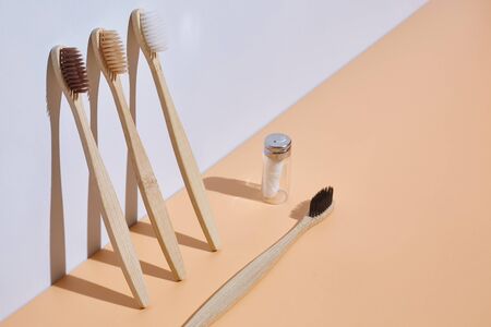 Wooden toothbrushes with dental floss. The concept of recycling garbage and zero waste. 3D Light background with copy space.の写真素材