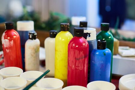 used bottles with acrylic paint are on the artist's desk.の写真素材