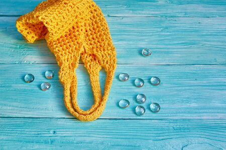 yellow string bag on a blue wooden backgroundの写真素材