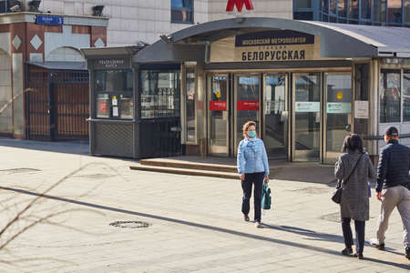 RUSSIA, MOSCOW, 03 28 2020 - a woman in a medical mask leaves the metro in the center of Moscow during the day during the period of self-isolation.のeditorial素材