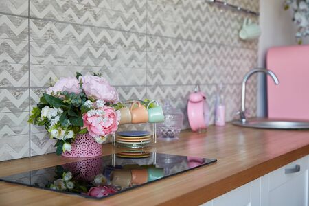 Interior of a modern kitchen set with a bouquet of flowers in a vase. background with copy space.の写真素材