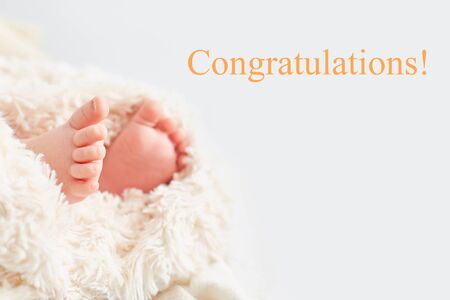 Close-up legs of the child and the inscription "Congratulations".の写真素材