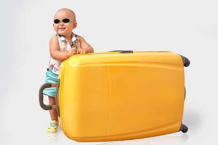 Todler with a big yellow suitcase.の写真素材