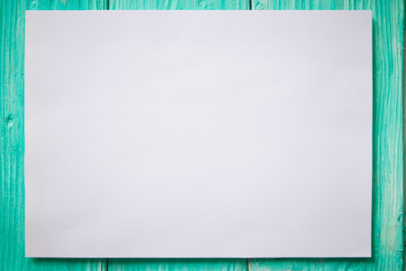 White mockup blank paper on green wooden background. Copy space for text.の写真素材