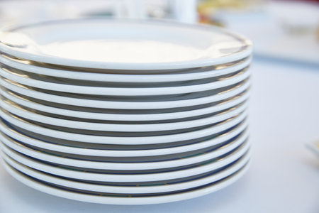 A stack of white plates on a light background. Life styleの写真素材
