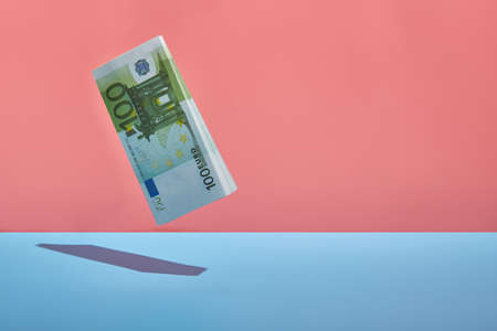 levitating wad of money with a hard sun shadow. Copy spaceの写真素材