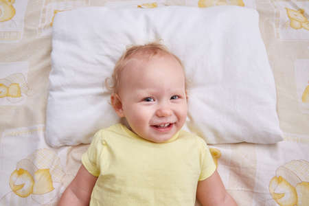 A smiling baby lies on a white pillow. pillowcase mockupの写真素材
