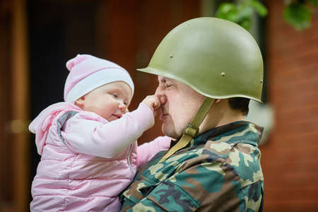 Baby Plays with her Soldier and Pulls his Nose.の写真素材