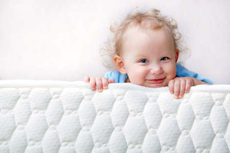 Baby on the bed mattress close-up. The sidewall of the mastras is stitched with finishing lines.の写真素材