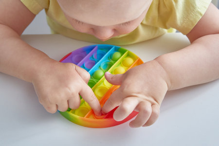 Anti stress toy Pop It. Close up Child Playing With The Pop It Fidget Toy. Happy childhood, popular educational games.の写真素材