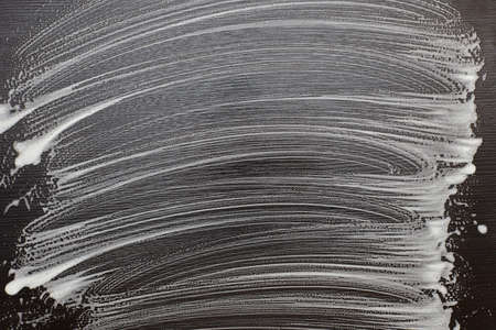 Soap foam on a black table. Foam traces on black background.の写真素材