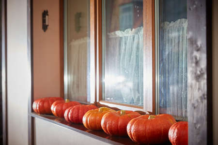 Halloween concept. A lot of pumpkins are lying on the window of the house. Decor for Halloween celebrationの写真素材