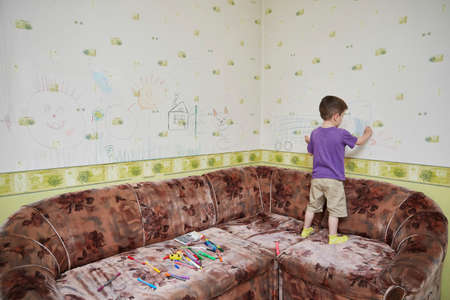 preschooler draws on the wallpaper in a room during lockdown and isolation during the  pandemic.の写真素材