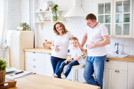 happy family in the kitchen of their home. A bright room and clothes.の写真素材