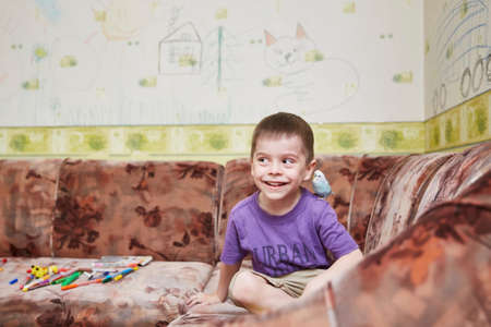 The boy playing with the parrot on his shoulders.の写真素材