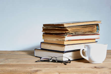 stack of books with a cup and glasses next to it. Space for text. The concept of training and education.の写真素材