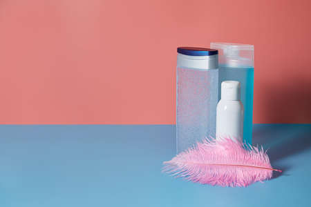 Tubes of cosmetics and creams stand on a blue and pink background. Copy space.の写真素材