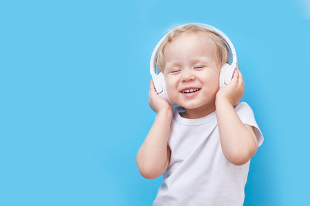 Headphones on the childs head. Listens to music and dances.の写真素材