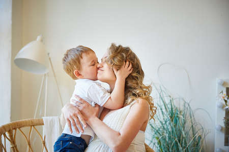 caucasian child boy kisses a pregnant happy motherの写真素材