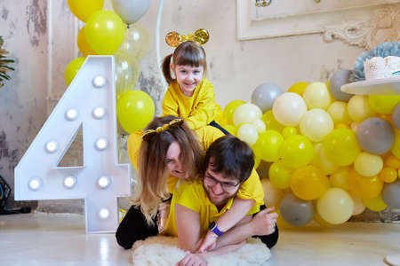 young family with a girl having fun at the celebration of their daughters fourth birthday.の写真素材