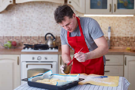 A man at home in the kitchen bakes piesの写真素材