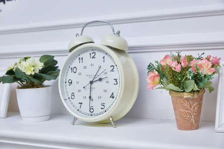 shelf with clocks and vases with flowers.の写真素材