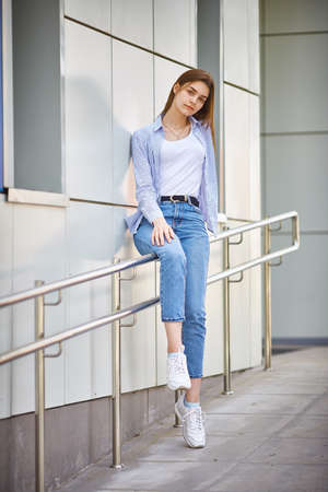 teenage girl near the institute building. school yard before classes lessons. New academic year semester. Welcome back to school. Full bodyの写真素材