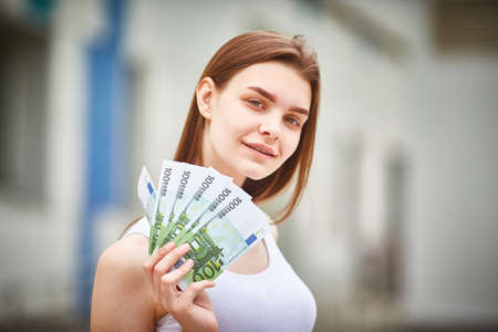 young woman took out a euro cash loan. Select focus on banknotes.の写真素材