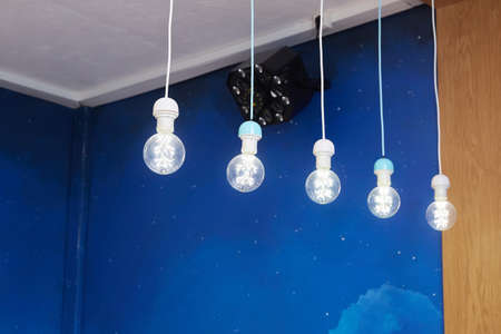 Edison Light bulbs in the childrens room with blue wallsの写真素材