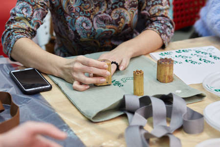 woman prints a pattern on a fabric shopping bag